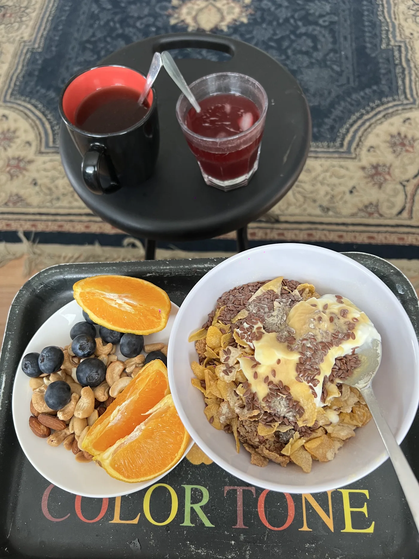 Breakfast tray with cereal bowl, orange slices, nuts and blueberries