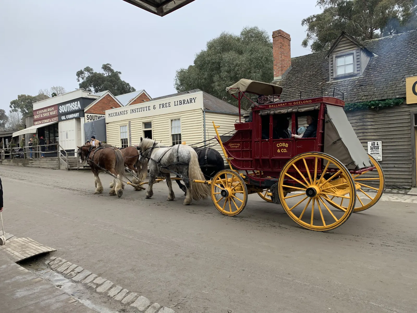 Green carriage passing the Apothecaries Hall at Sovereign Hill