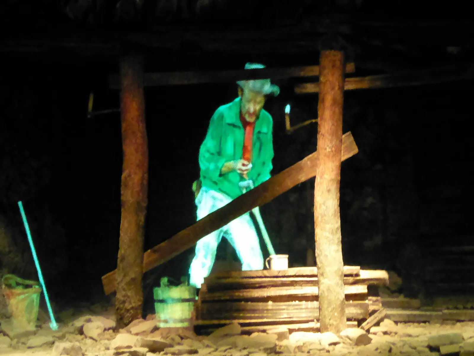 Projected miner figure among timber supports in the underground mine