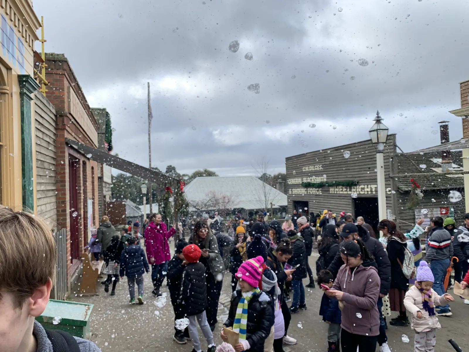 Crowds in the street at Sovereign Hill with artificial snow falling