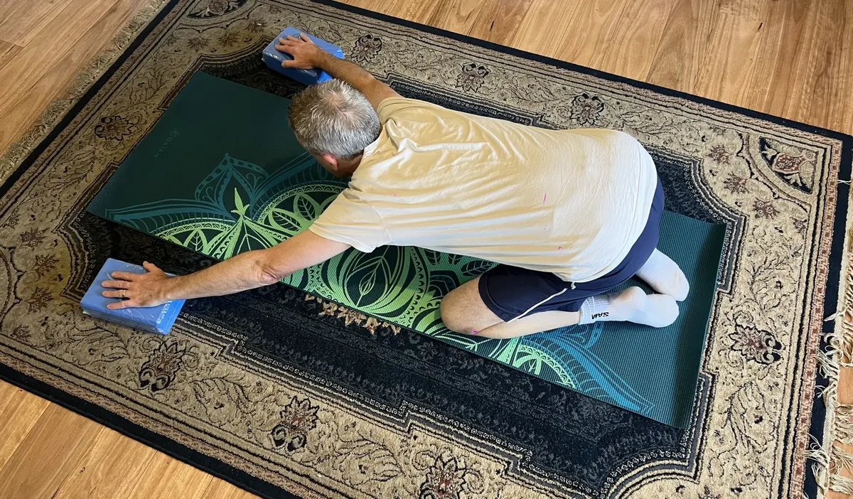 Child's pose stretch with hands on yoga blocks